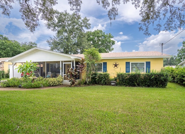 single story home featuring a sunroom and a front yard