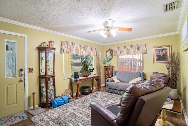 living room featuring ceiling fan, ornamental molding, wood finished floors, and visible vents