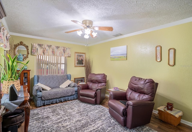 living area with ceiling fan, ornamental molding, wood finished floors, and visible vents