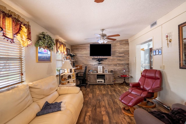 living area with a textured ceiling, ceiling fan, wood finished floors, visible vents, and vaulted ceiling