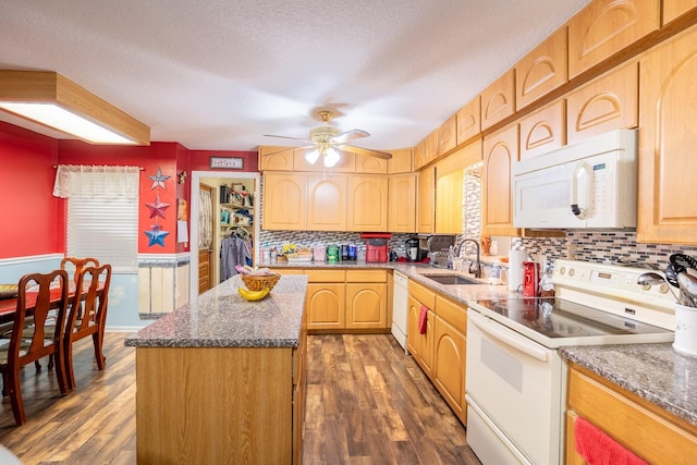 kitchen with dark wood-style floors, white appliances, a sink, and a kitchen island