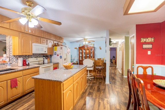 kitchen featuring white appliances, backsplash, a kitchen island, and dark wood finished floors