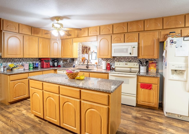 kitchen featuring dark wood finished floors, white appliances, a sink, and ceiling fan