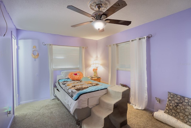 bedroom featuring a textured ceiling, carpet flooring, a ceiling fan, and baseboards