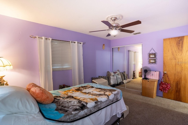 carpeted bedroom featuring a closet, visible vents, and ceiling fan