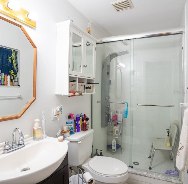 full bathroom with a stall shower, visible vents, vanity, and toilet