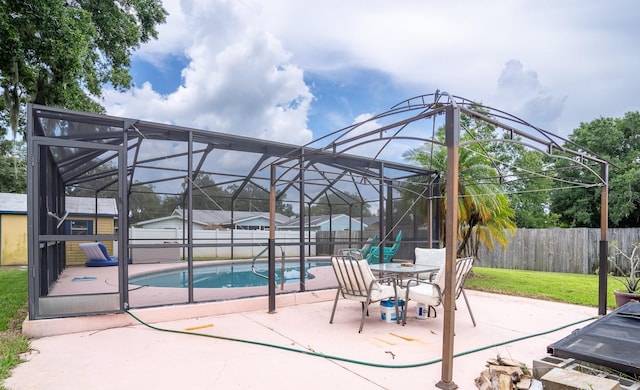 view of patio / terrace with glass enclosure, a fenced backyard, and a fenced in pool