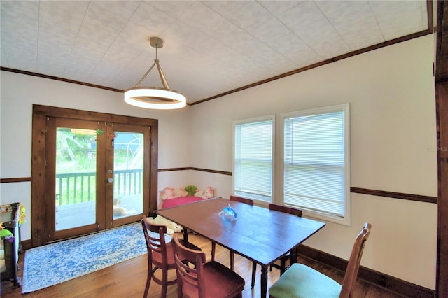 dining area featuring french doors, crown molding, and wood-type flooring