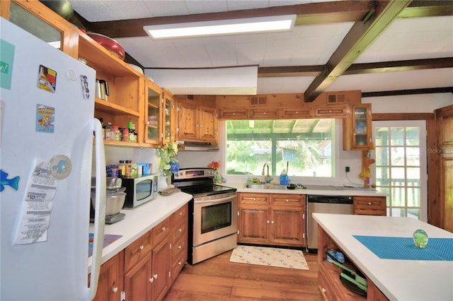 kitchen featuring appliances with stainless steel finishes, sink, plenty of natural light, and light hardwood / wood-style flooring