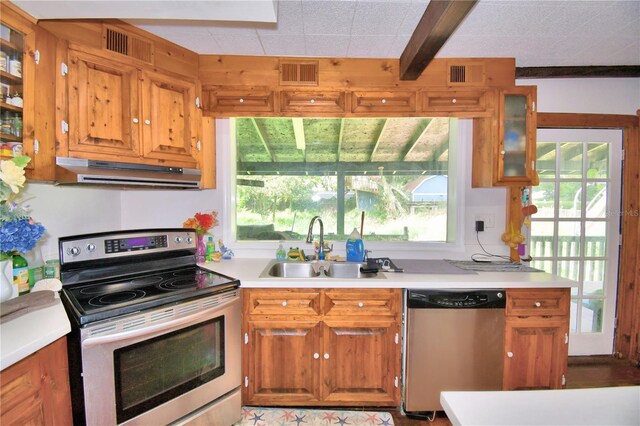 kitchen featuring beamed ceiling, sink, stainless steel appliances, and plenty of natural light