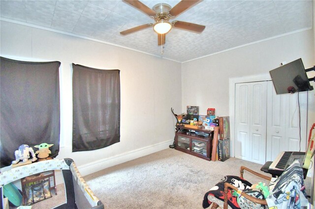 interior space featuring ceiling fan, crown molding, and carpet floors