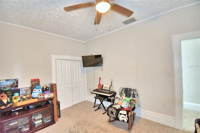 rec room featuring ceiling fan, light carpet, and crown molding