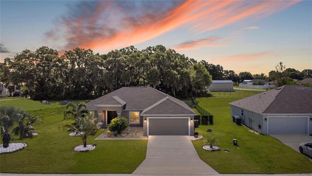 view of front of property featuring a garage, a yard, and cooling unit