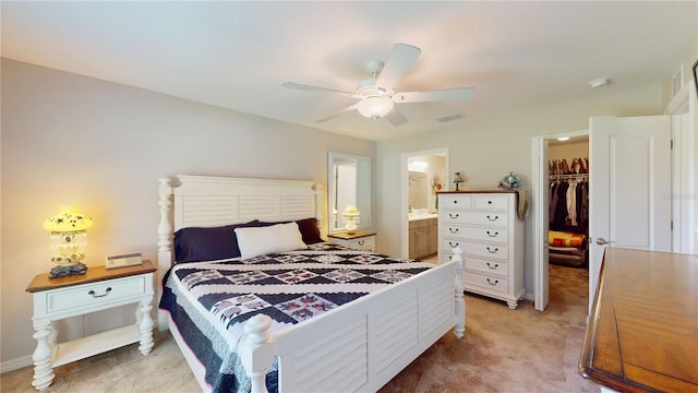 carpeted bedroom featuring ceiling fan, a spacious closet, a closet, and ensuite bathroom