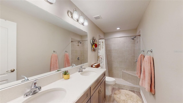 bathroom with toilet and double sink vanity