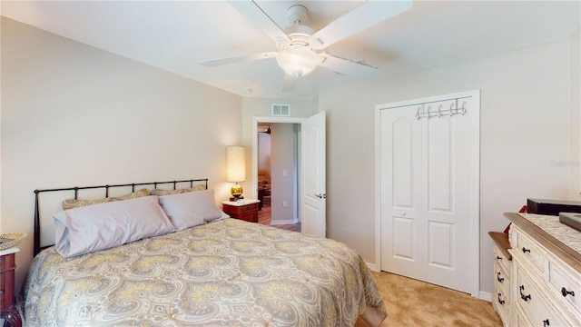 carpeted bedroom with ceiling fan and a closet