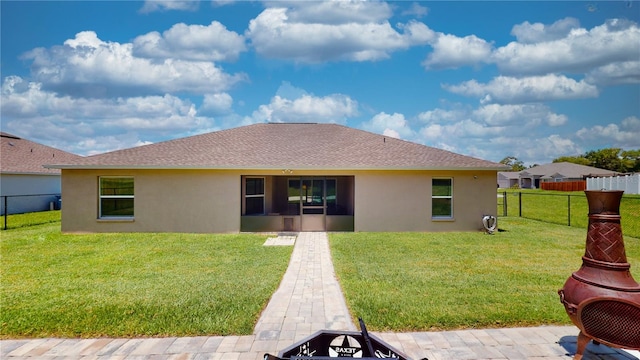 rear view of property featuring a lawn