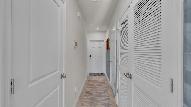 corridor with light wood-style floors, recessed lighting, and baseboards