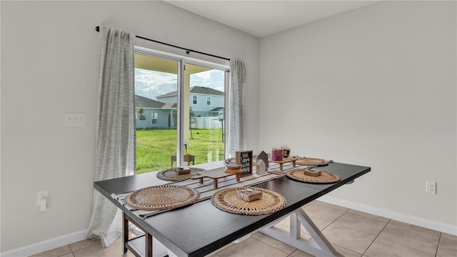 dining area featuring light tile patterned floors and baseboards