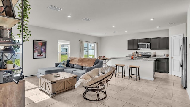 living area with recessed lighting, visible vents, and light tile patterned floors