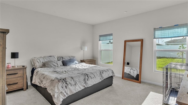 bedroom with baseboards and light colored carpet