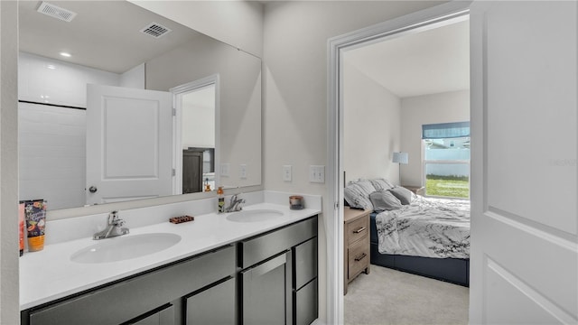 ensuite bathroom with connected bathroom, visible vents, and a sink