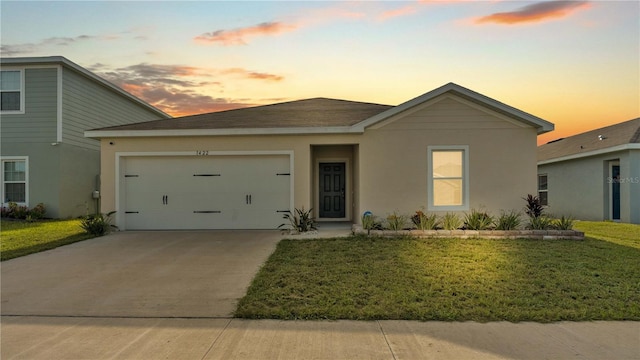 ranch-style house with concrete driveway, stucco siding, an attached garage, and a front yard