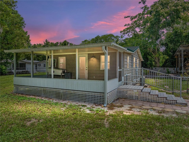 property exterior at dusk featuring a yard