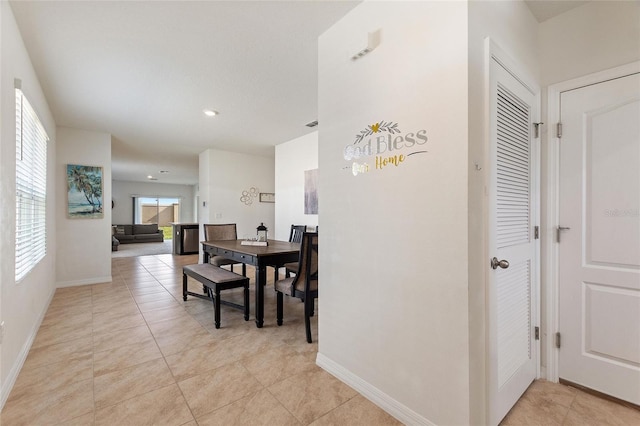 hallway with a wealth of natural light and light tile patterned floors