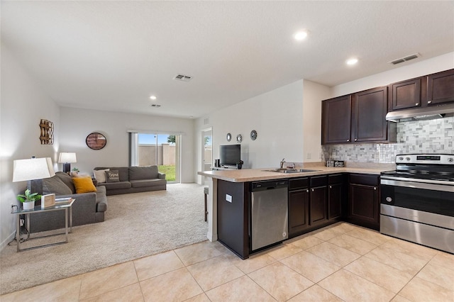 kitchen with kitchen peninsula, appliances with stainless steel finishes, light tile patterned flooring, and dark brown cabinetry