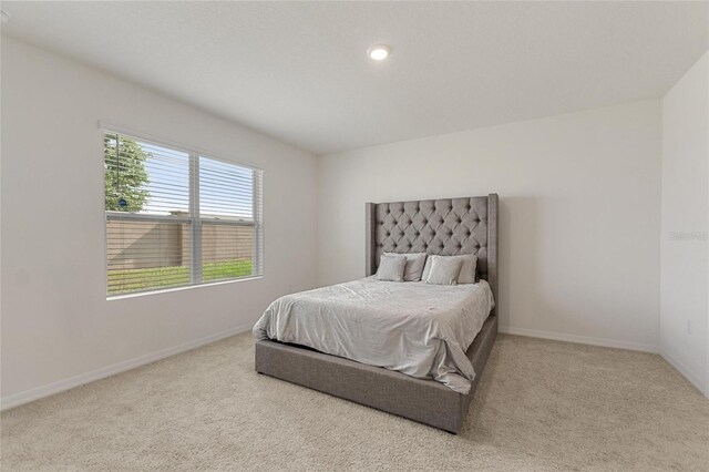 bedroom featuring light colored carpet