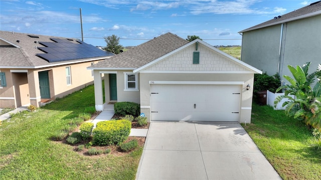 view of front of home with a front yard, solar panels, and a garage