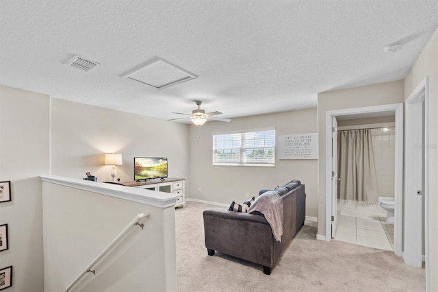 carpeted living room featuring a textured ceiling and ceiling fan