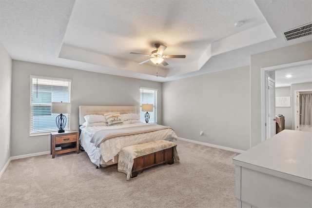 9681 Flourish Dr, Land O Lakes, FL 34637 - bedroom with a tray ceiling, light carpet, baseboards, a textured ceiling, and ceiling fan