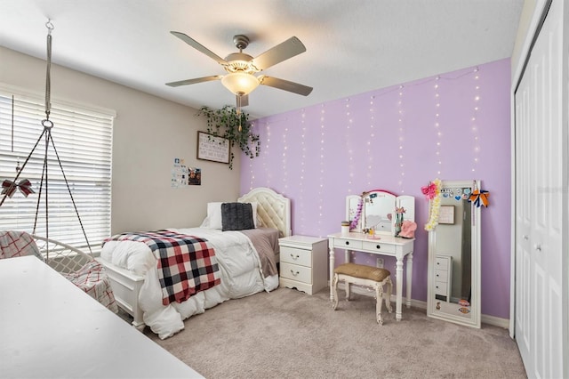 bedroom featuring a closet, a ceiling fan, light carpet, baseboards, and wallpapered walls