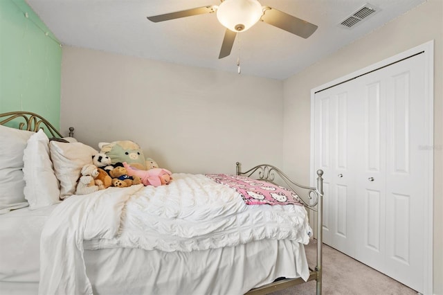 bedroom featuring a ceiling fan, light colored carpet, a closet, and visible vents