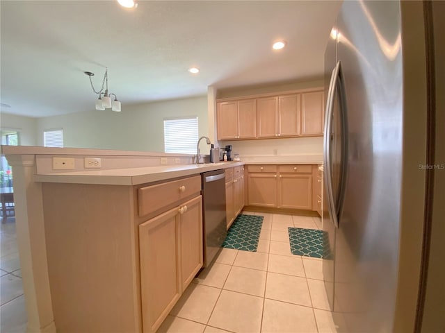 kitchen with decorative light fixtures, light brown cabinets, light tile patterned floors, stainless steel appliances, and kitchen peninsula