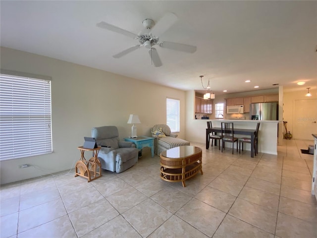 living room featuring ceiling fan, sink, and light tile patterned flooring