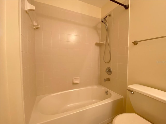 bathroom featuring tiled shower / bath and toilet