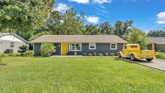 ranch-style house featuring central air condition unit and a front yard