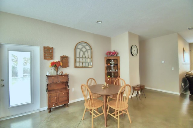 dining room featuring concrete flooring and a textured ceiling