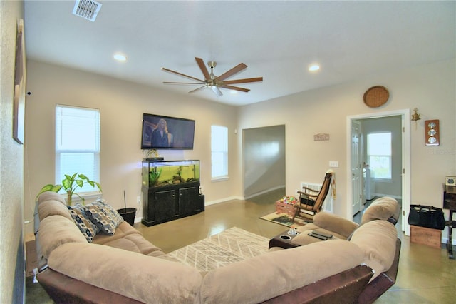 living room with ceiling fan and concrete flooring