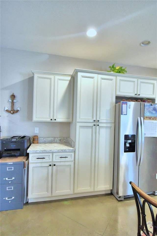 kitchen with light tile patterned flooring, white cabinetry, light stone counters, and stainless steel refrigerator with ice dispenser