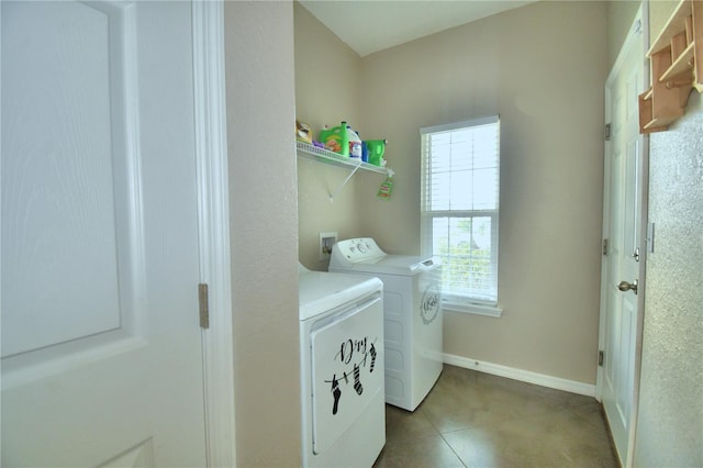 laundry room with washer and clothes dryer and light tile patterned floors