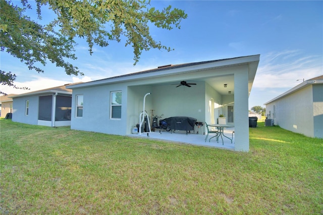 rear view of house featuring ceiling fan, a patio area, and a yard