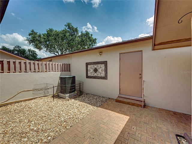 doorway to property featuring central AC unit and a patio area