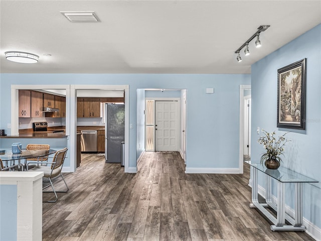 interior space featuring dark hardwood / wood-style flooring and track lighting