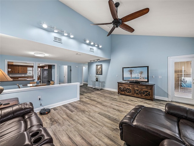 living room with ceiling fan, vaulted ceiling, hardwood / wood-style flooring, and track lighting