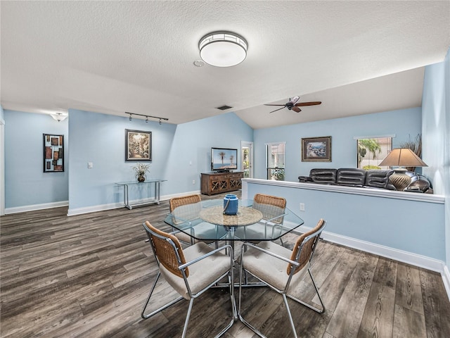 dining area featuring ceiling fan, wood-type flooring, a textured ceiling, and lofted ceiling