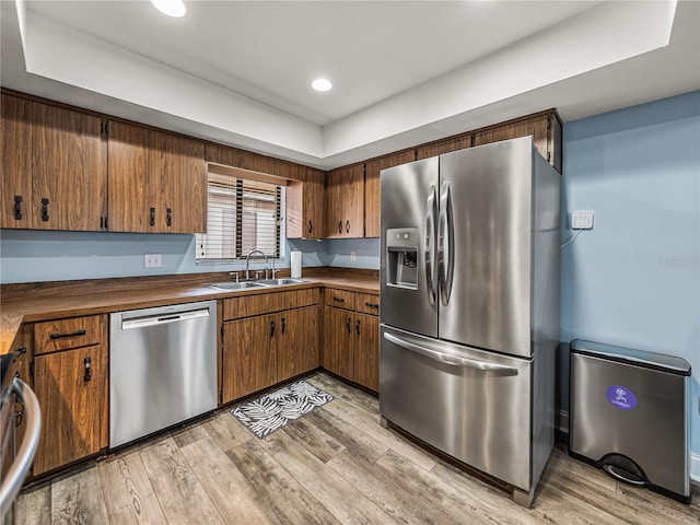 kitchen with sink, light hardwood / wood-style flooring, and stainless steel appliances